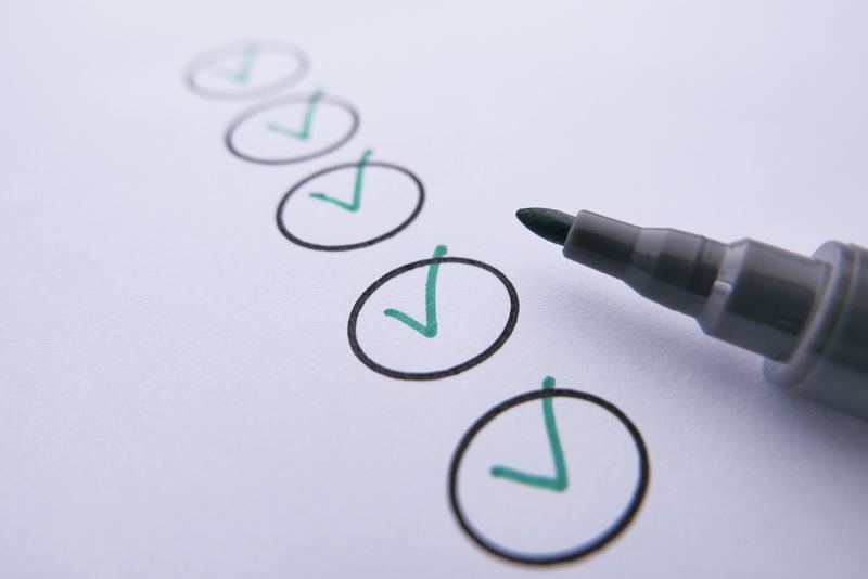 A column of hand-drawn checkmarks in circles on paper beside a marker pen