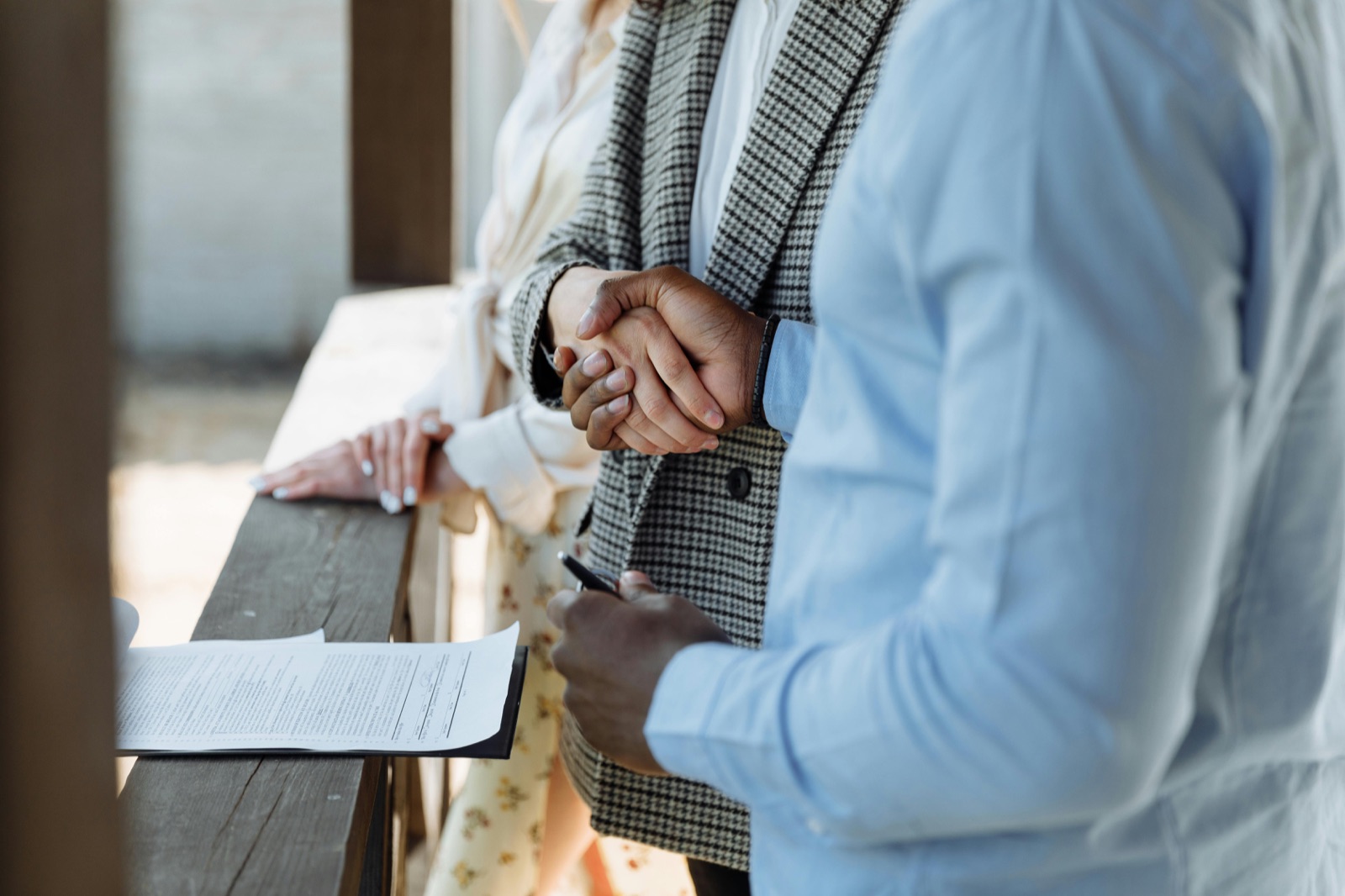 Two people shaking hands, one holding a clipboard